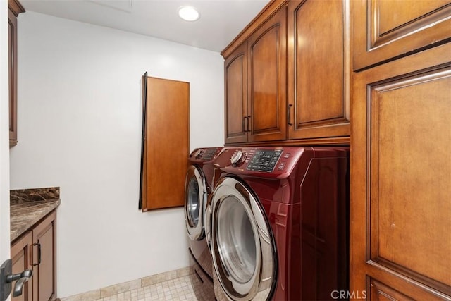 clothes washing area with cabinets and washing machine and dryer