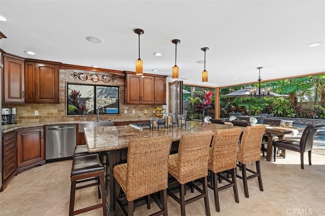 kitchen with decorative light fixtures, dishwasher, a center island, a kitchen bar, and sink