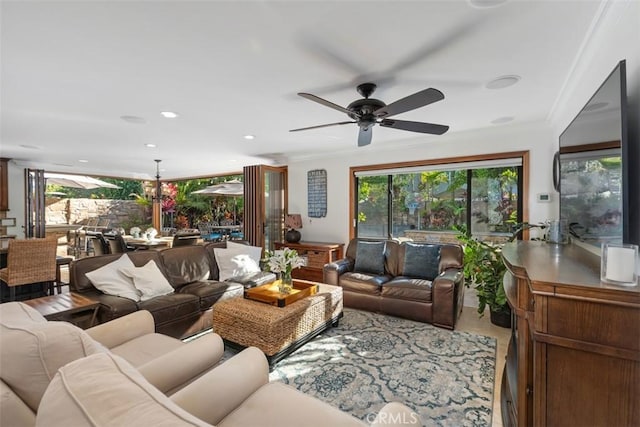 living room featuring ceiling fan, ornamental molding, and a healthy amount of sunlight