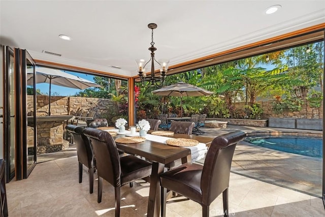 dining space featuring a chandelier, crown molding, and plenty of natural light