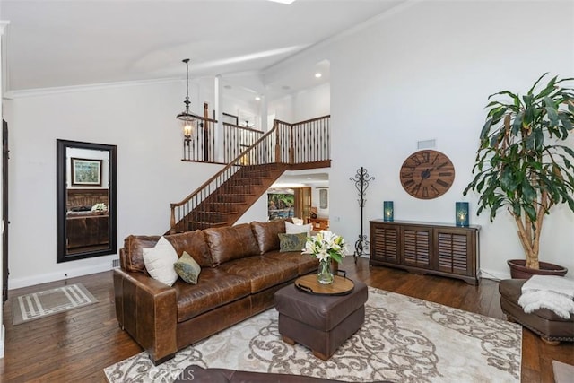 living room featuring an inviting chandelier, ornamental molding, and dark hardwood / wood-style flooring