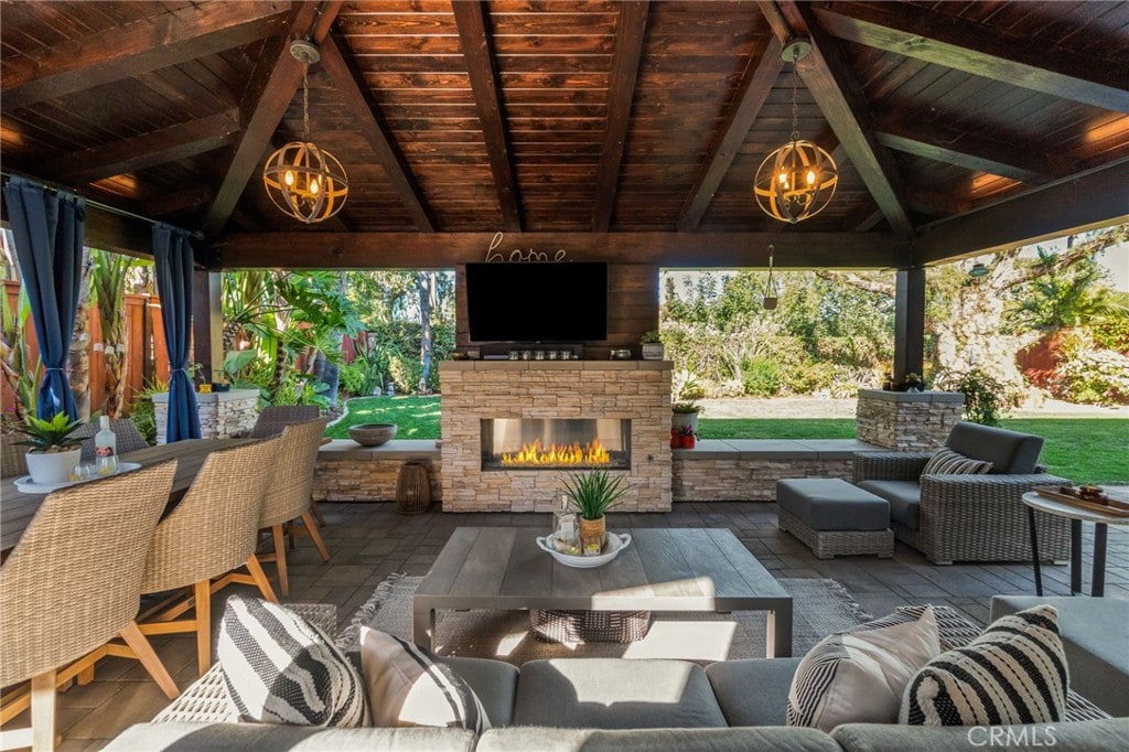 view of patio / terrace featuring an outdoor living space with a fireplace and a gazebo