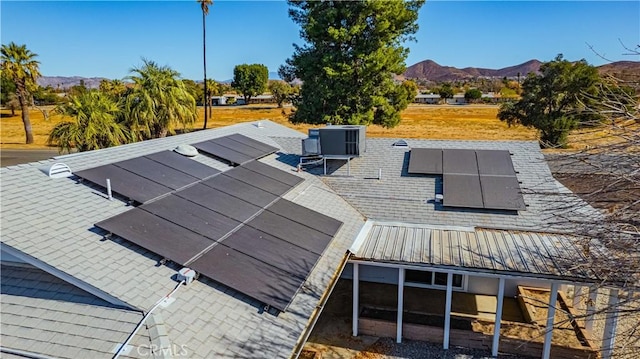 exterior space with central AC, solar panels, and a mountain view