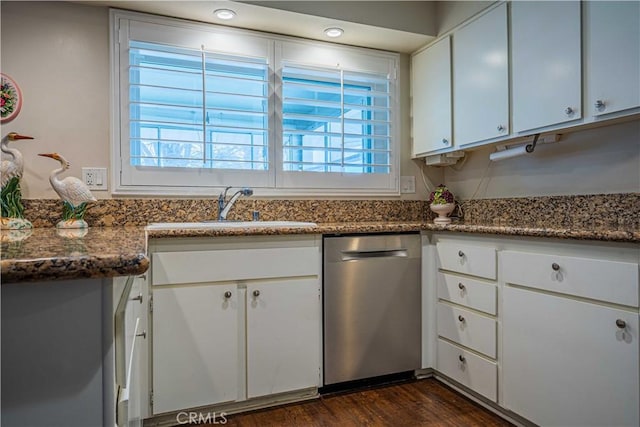 kitchen with sink, white cabinetry, dark stone countertops, stainless steel dishwasher, and dark wood-type flooring