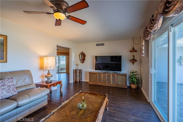 living room featuring ceiling fan and dark hardwood / wood-style floors