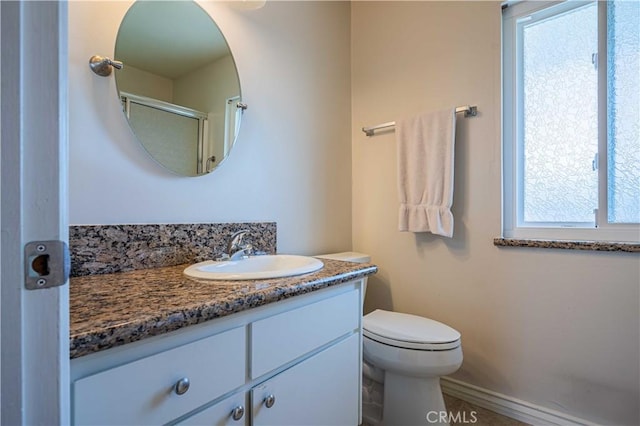 bathroom featuring toilet, a wealth of natural light, and vanity