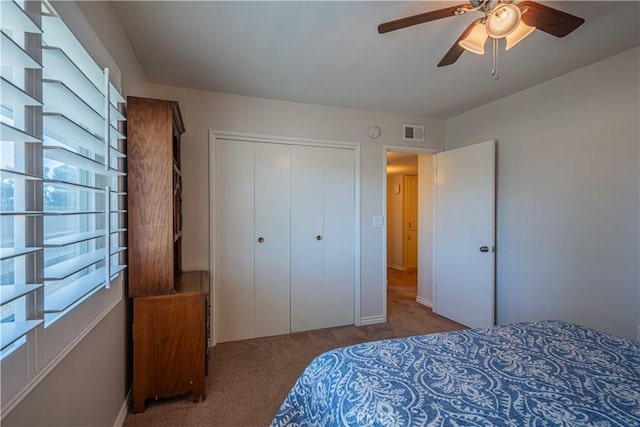 bedroom featuring ceiling fan, multiple windows, a closet, and light carpet