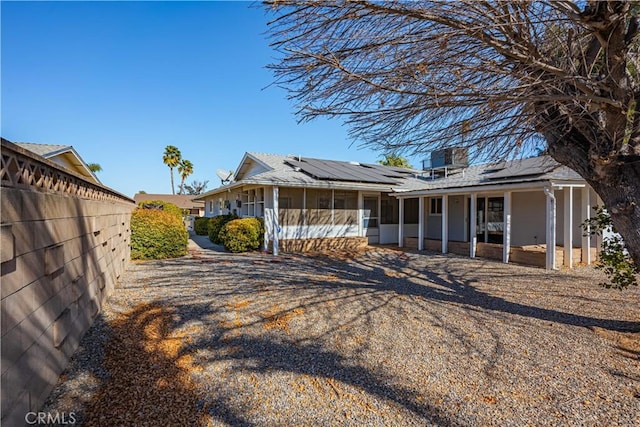 exterior space featuring solar panels and a sunroom