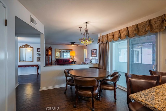 dining room with ceiling fan and dark wood-type flooring