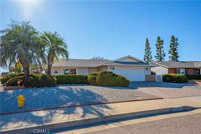 single story home with a garage and central AC unit