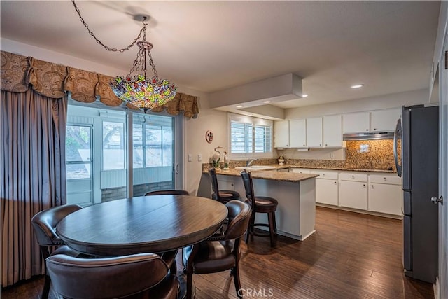 dining space with sink and dark hardwood / wood-style flooring