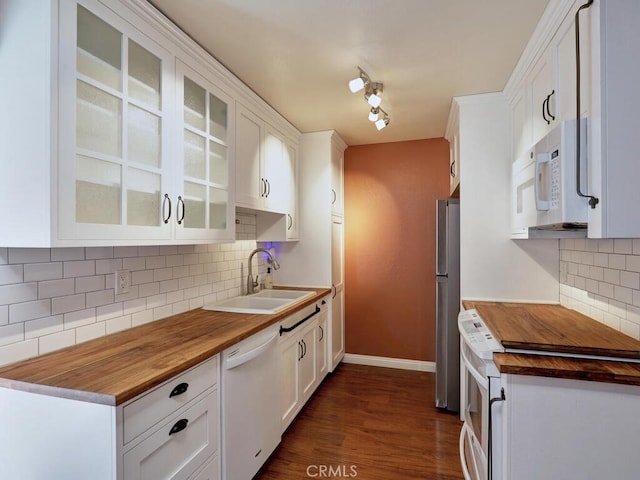 kitchen with white appliances, dark wood-type flooring, decorative backsplash, white cabinets, and sink