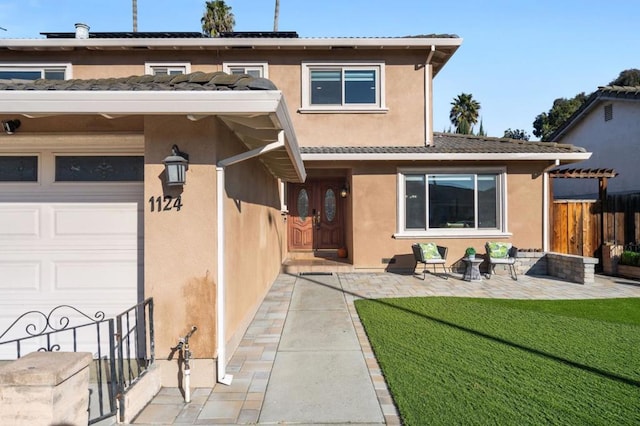 rear view of property with a garage and a lawn