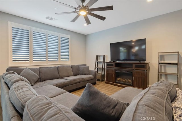 living room featuring light wood-type flooring and ceiling fan