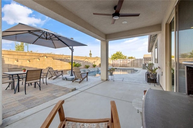 view of patio featuring ceiling fan and a fenced in pool