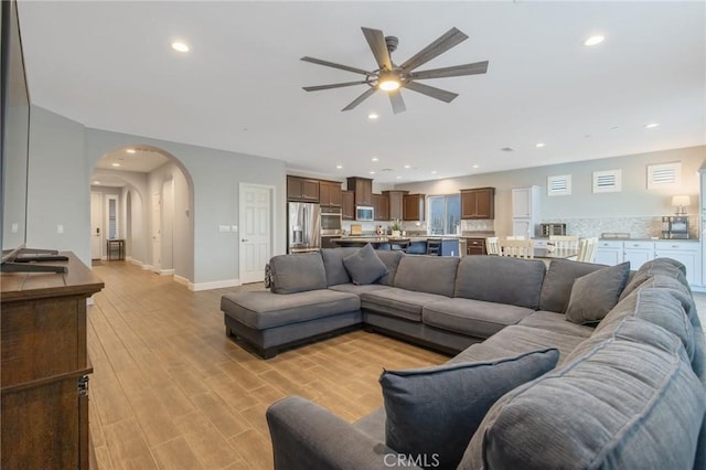 living room featuring ceiling fan and light hardwood / wood-style floors