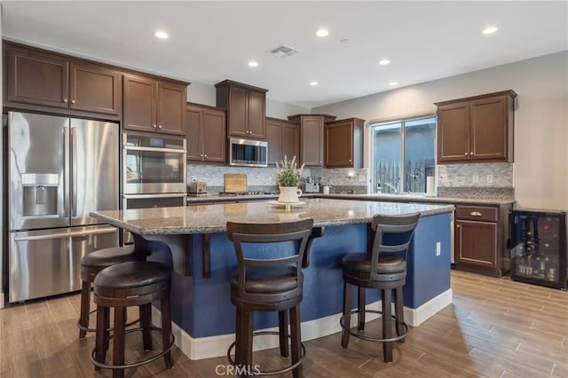 kitchen with a kitchen island, stainless steel appliances, and a kitchen breakfast bar