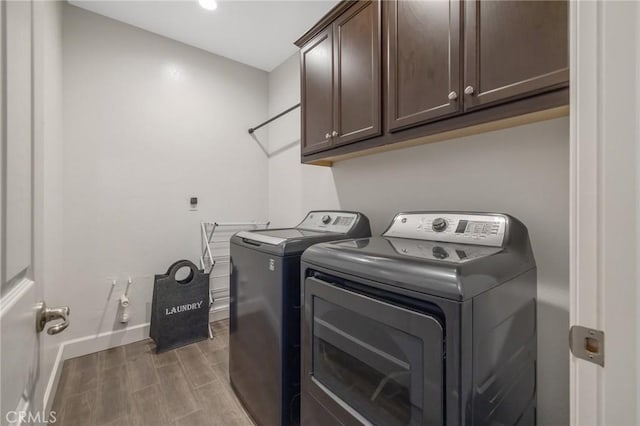 laundry area with washer and dryer and cabinets