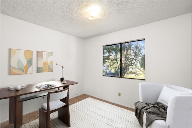 home office with a textured ceiling, baseboards, and carpet flooring