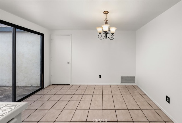 spare room with a chandelier, visible vents, and baseboards