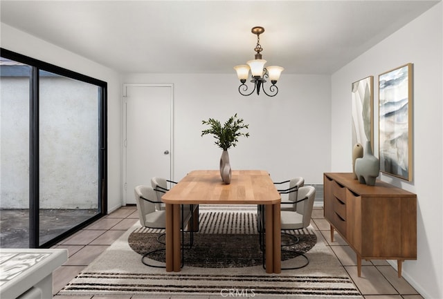 dining room featuring light tile patterned floors, baseboards, and a notable chandelier