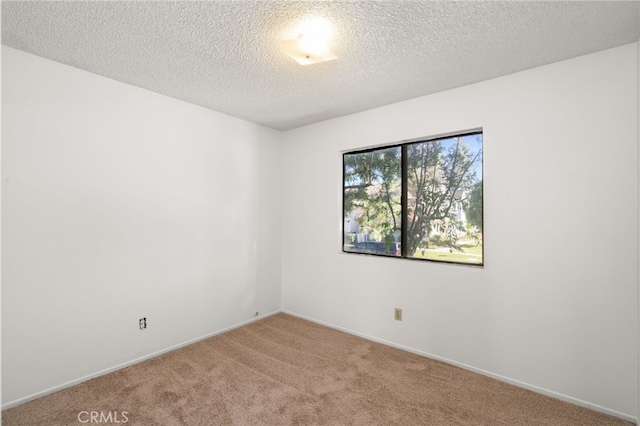 unfurnished room featuring carpet, baseboards, and a textured ceiling