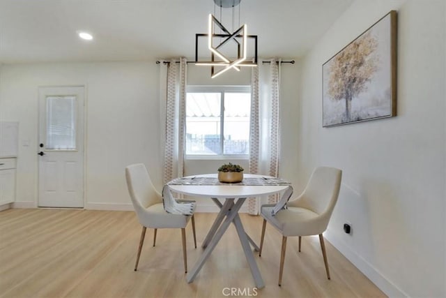 dining area featuring a notable chandelier and light wood-type flooring