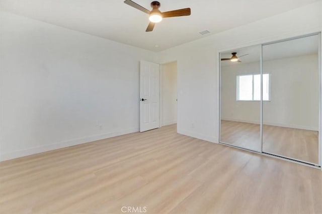 unfurnished bedroom featuring ceiling fan, a closet, and light hardwood / wood-style flooring