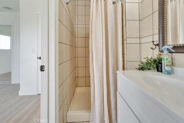 bathroom with vanity, a shower with shower curtain, and hardwood / wood-style floors