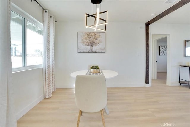 dining space featuring a notable chandelier, light hardwood / wood-style flooring, and a wealth of natural light