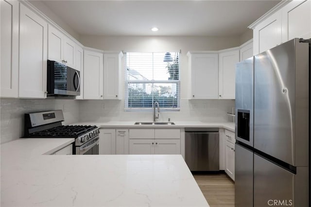 kitchen featuring stainless steel appliances, white cabinets, and sink