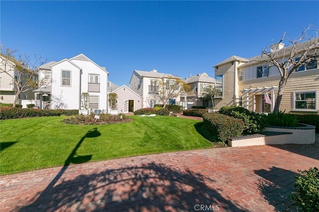 view of property's community with a pergola, a yard, and a patio