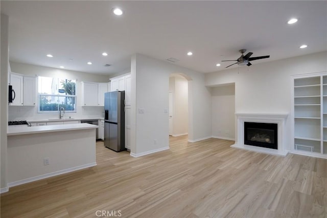 kitchen featuring sink, white cabinets, ceiling fan, light hardwood / wood-style flooring, and appliances with stainless steel finishes