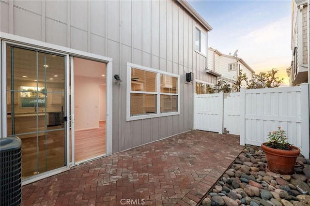 patio terrace at dusk featuring central AC unit