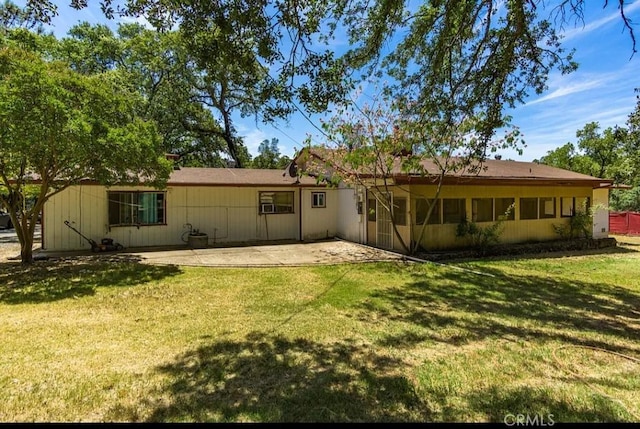 rear view of property featuring a patio area and a lawn