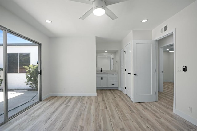 unfurnished bedroom featuring light hardwood / wood-style flooring, ensuite bathroom, ceiling fan, access to exterior, and sink