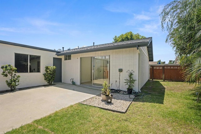 rear view of property with a patio and a lawn