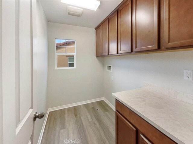 laundry area featuring cabinets, hookup for a washing machine, and light hardwood / wood-style floors