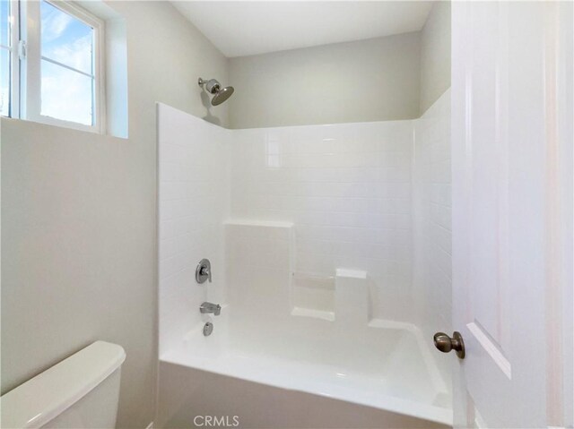 bathroom featuring shower / tub combination and toilet