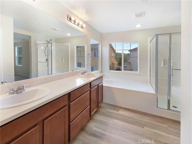 bathroom featuring hardwood / wood-style flooring, vanity, and separate shower and tub