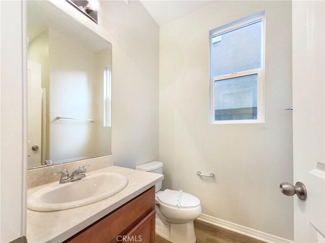 bathroom featuring vanity, hardwood / wood-style flooring, and toilet