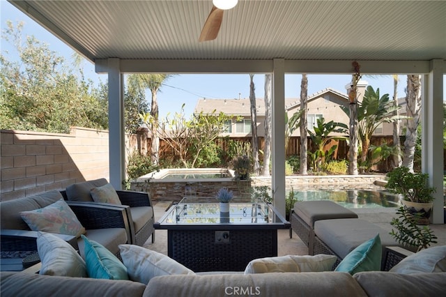 view of patio featuring ceiling fan, an outdoor living space with a fire pit, and a hot tub