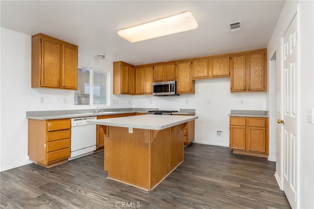 kitchen with dark wood-type flooring, dishwasher, a kitchen bar, and a center island