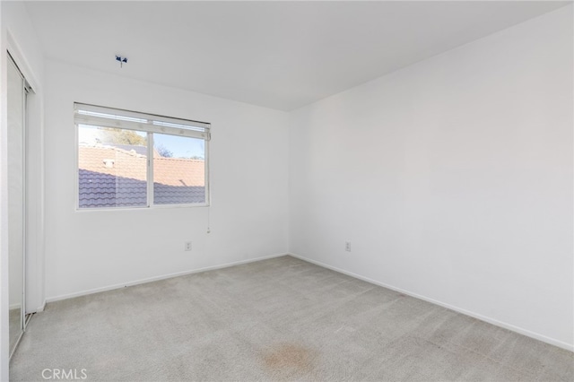 unfurnished room featuring light colored carpet