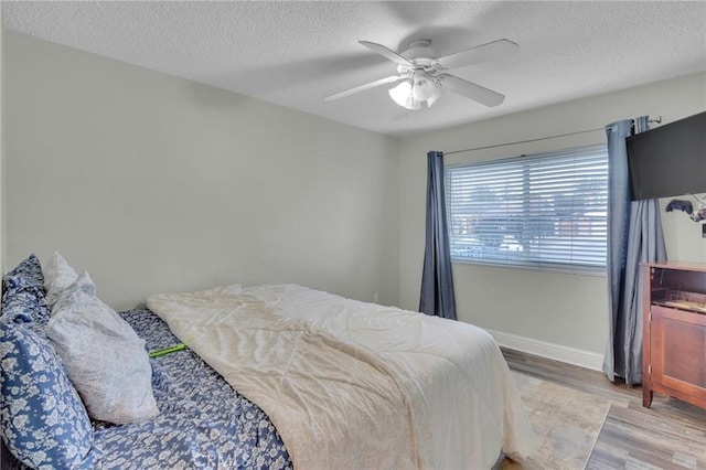 bedroom featuring a textured ceiling, ceiling fan, and light hardwood / wood-style floors