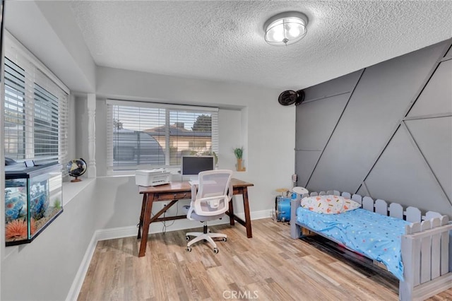 bedroom featuring light wood-type flooring and a textured ceiling