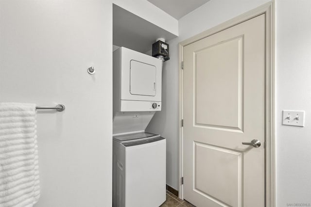 clothes washing area with tile patterned floors and stacked washing maching and dryer