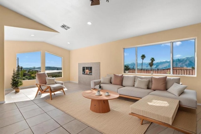 tiled living room featuring lofted ceiling and a tile fireplace