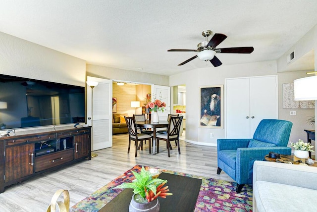 living room featuring light wood-type flooring and ceiling fan