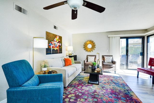 living room featuring ceiling fan and hardwood / wood-style flooring